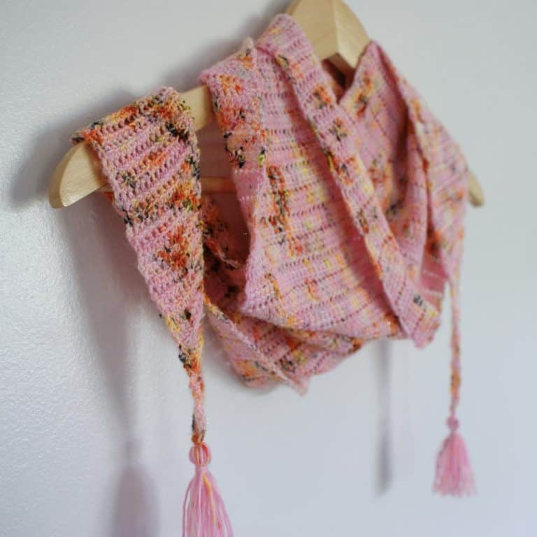 Pink leopard print crochet scarf with tassels on hangar