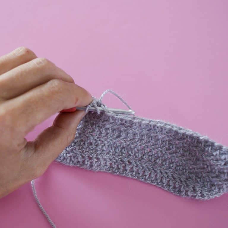 Herringbone Crochet Stitch Tutorial in Grey Alpaca Silk Yarn on a Pink Background