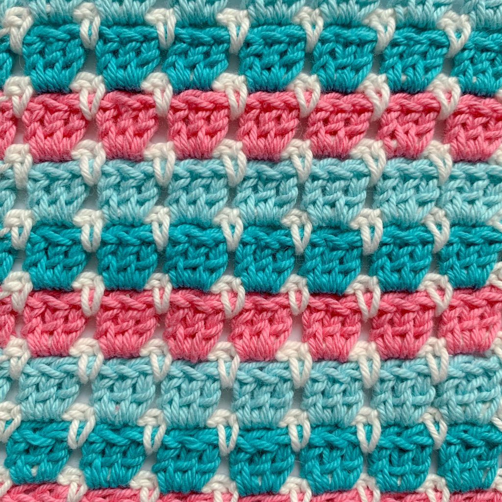 Close up of block stitch pink Aqua, turquoise and white crochet swatch