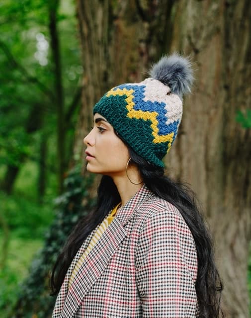A woman wears a crochet corner to corner zig zag hat