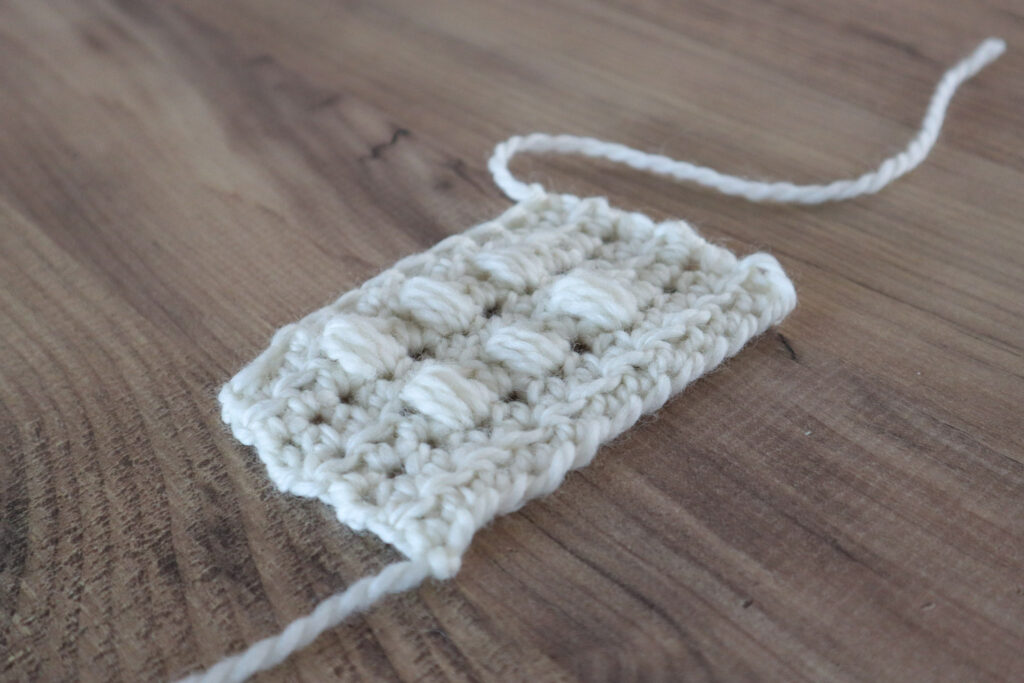 A side angle of a swatch of crochet puff bobble dot stitches showing the 3d texture.