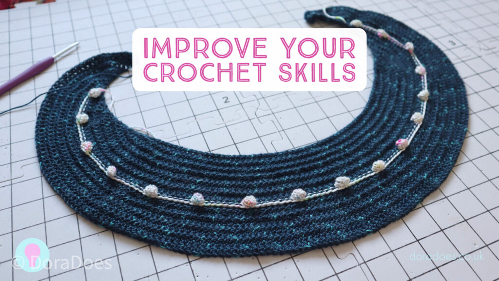 A partially made crochet crescent shawl in blue yarn with white bobbles. A text overlay reads ‘improve your crochet skills’.