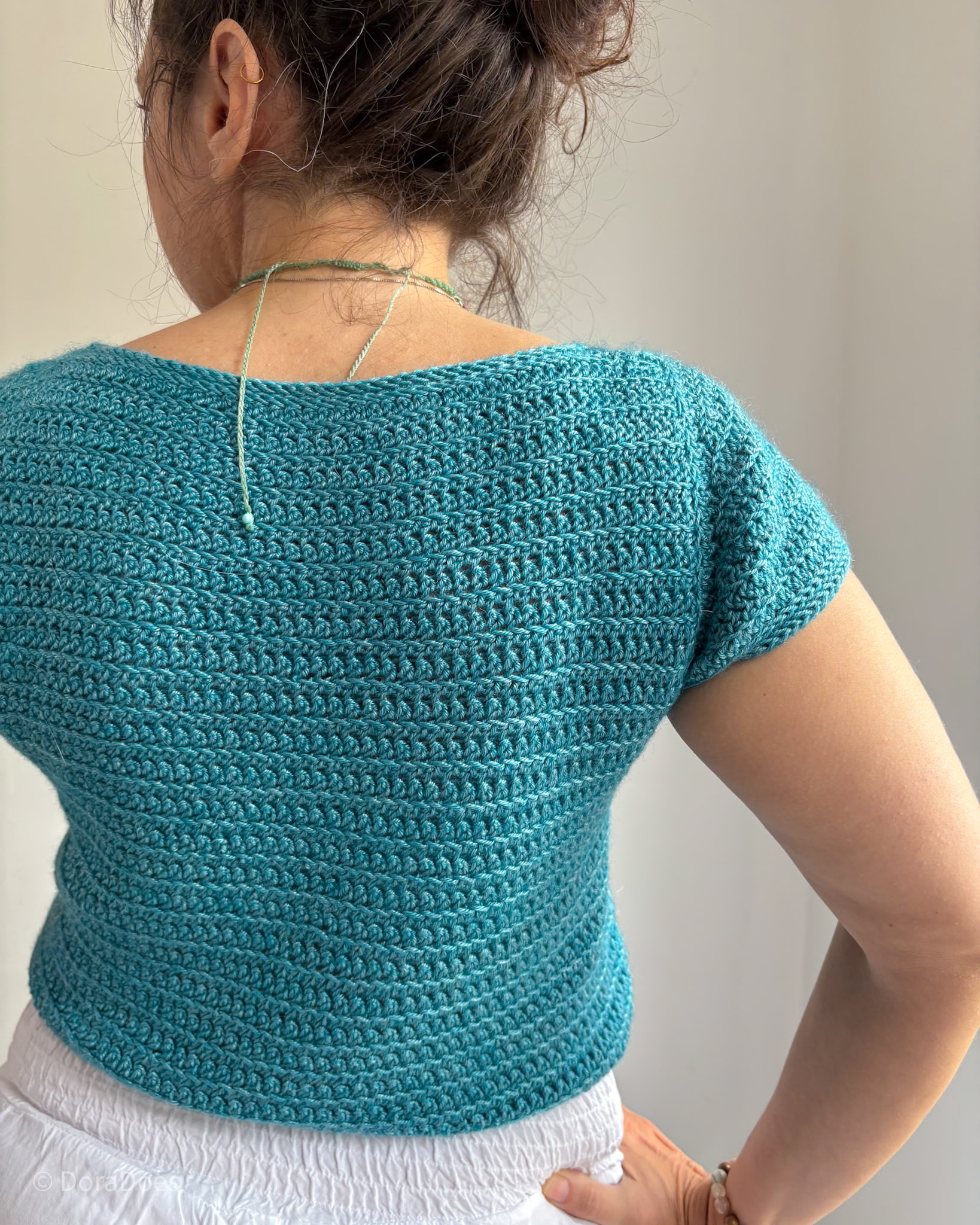 A close up view of the back of the spin off crochet top as worn by Dora.