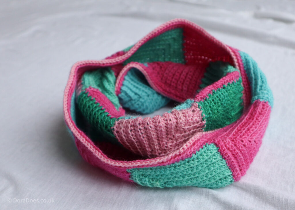 A crochet cowl made from mitred crochet squares.