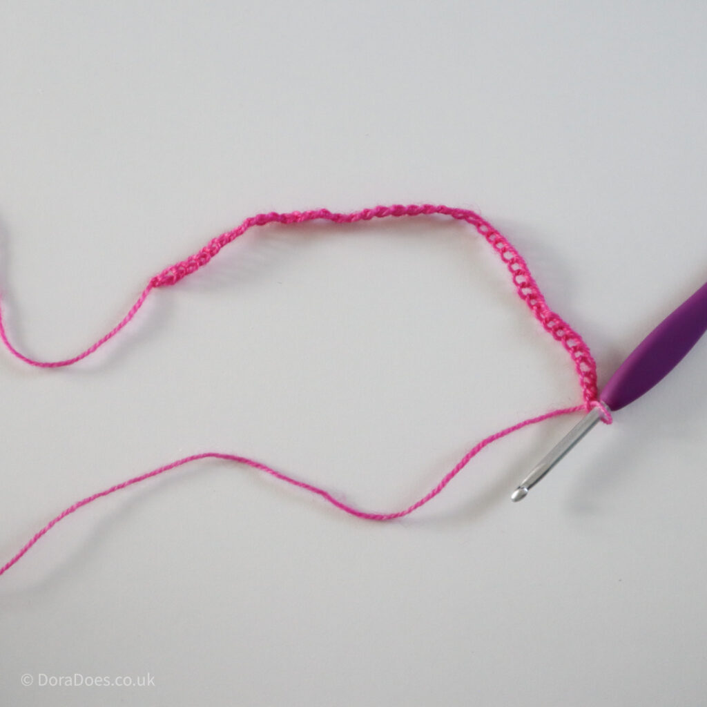 Crochet mitred square tutorial using pink yarn and a 4mm crochet hook: Step 1.
