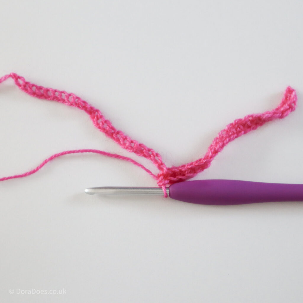 Crochet mitred square tutorial using pink yarn and a 4mm crochet hook, crocheting into the chain: Step 2.