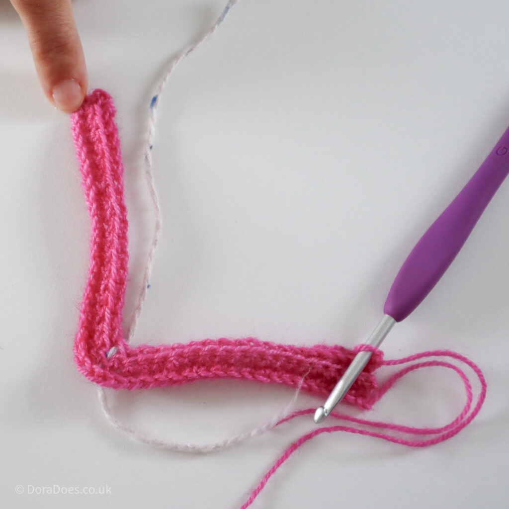 Crochet mitred square tutorial using pink yarn and a 4mm crochet hook after 2 full rows: Step 8.