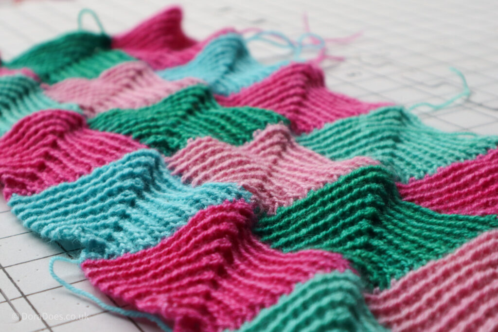 A low angle view of a series of crochet squares joined together.