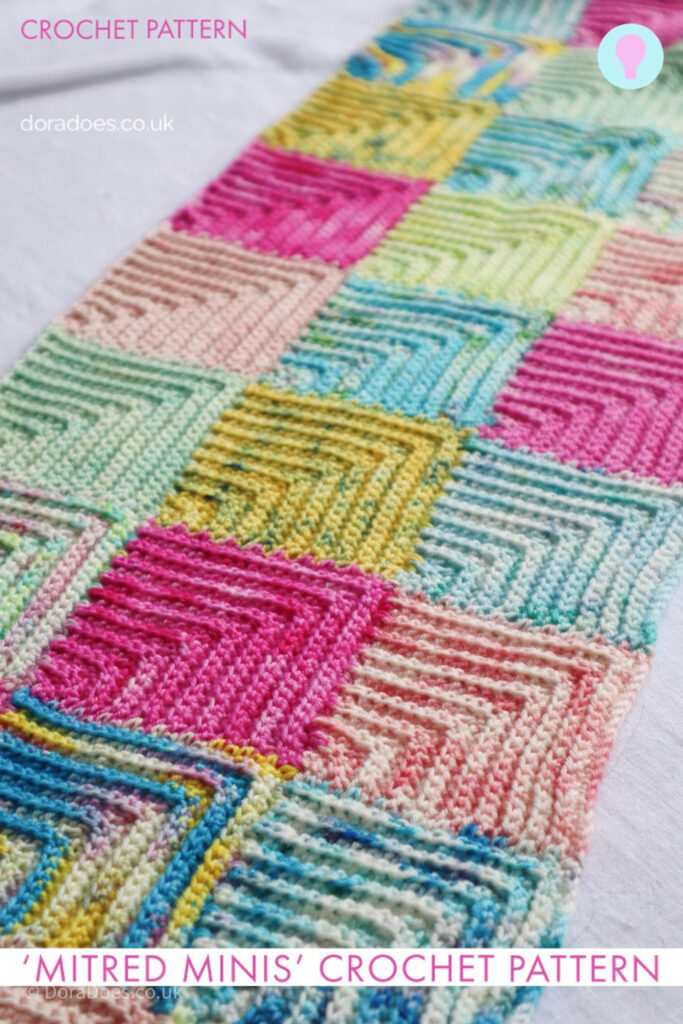 A graphic with an image of a mitred square crochet scarf in colourful hand dyed yarns. A text overlay reads ‘mitred minis’ crochet pattern.