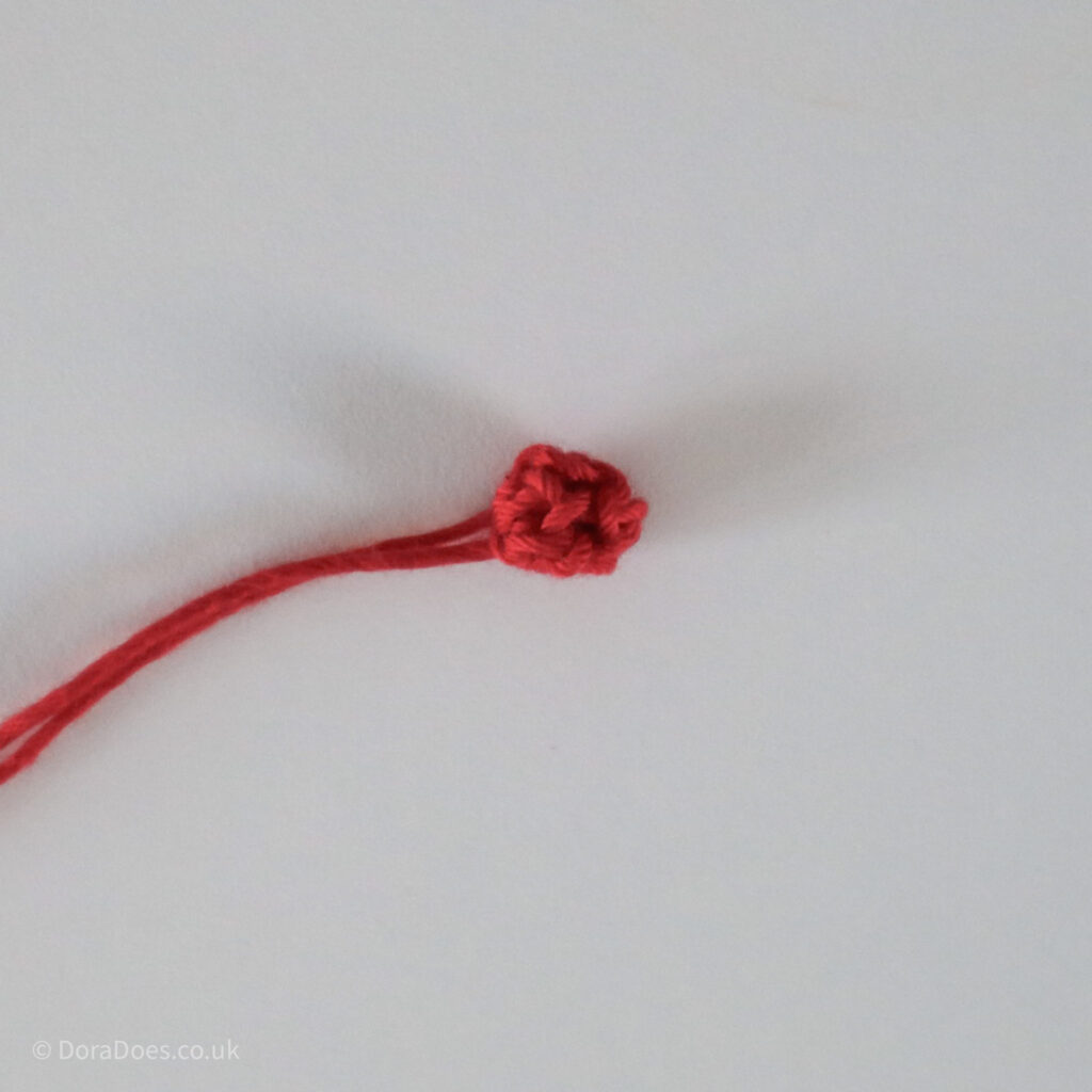 Crochet Holly Berry Tutorial step showing the finished berry with ends still attached.