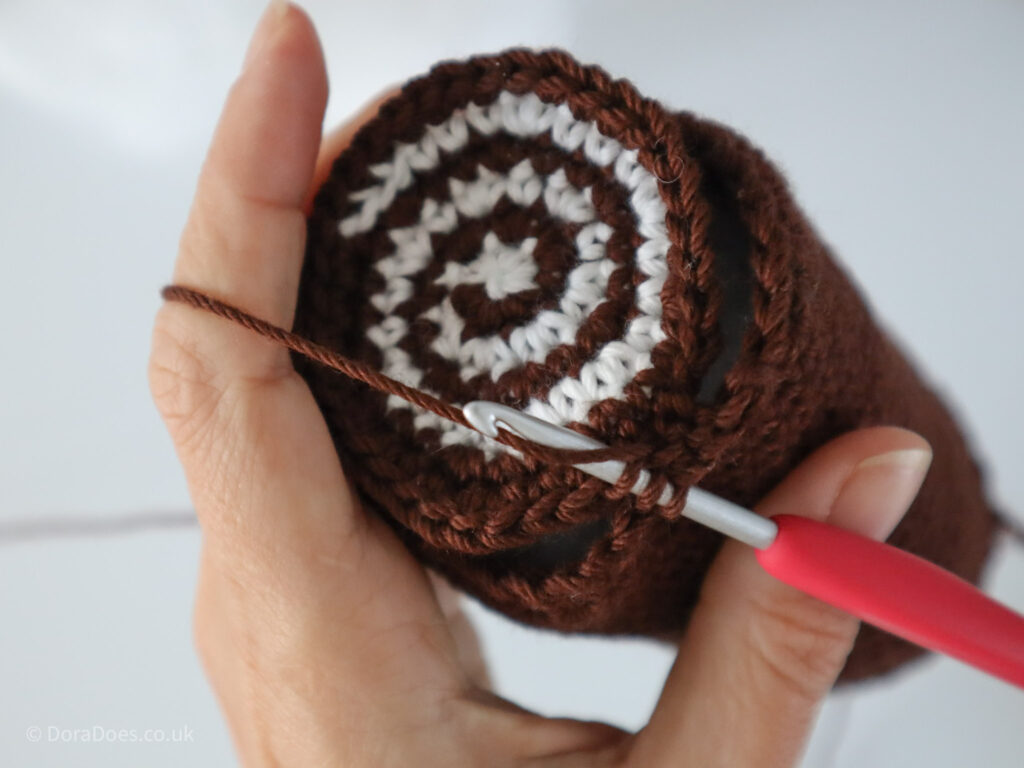 A close up of the start of the process of joining the second, spiralled end to a crochet log.