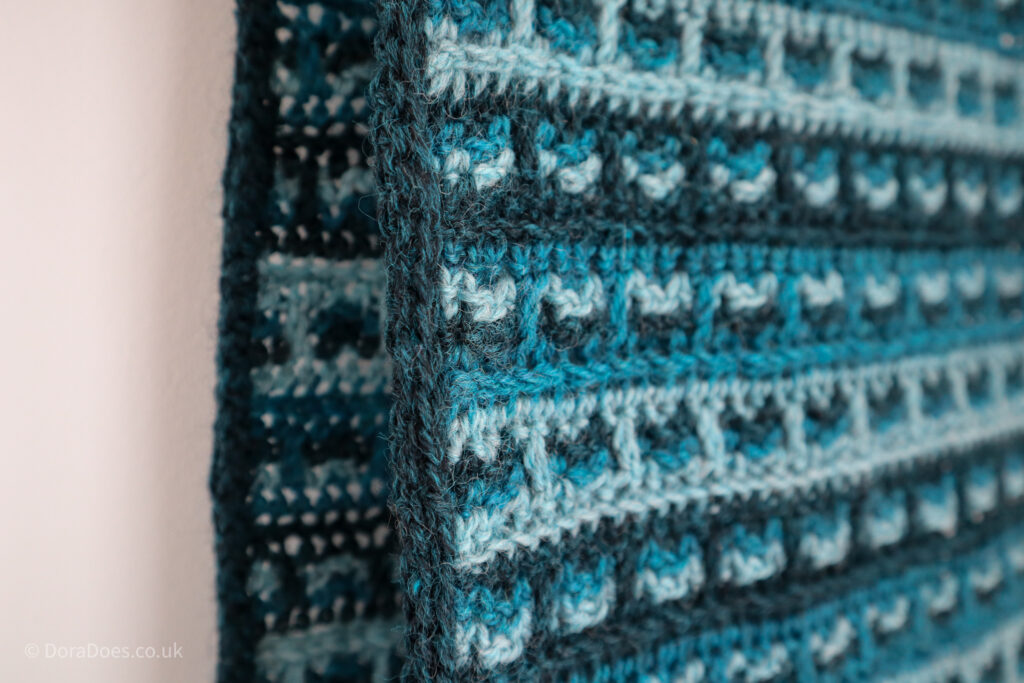 A close up of the envelope border on the crochet triple check wrap, a crochet scarf made in three colours.
