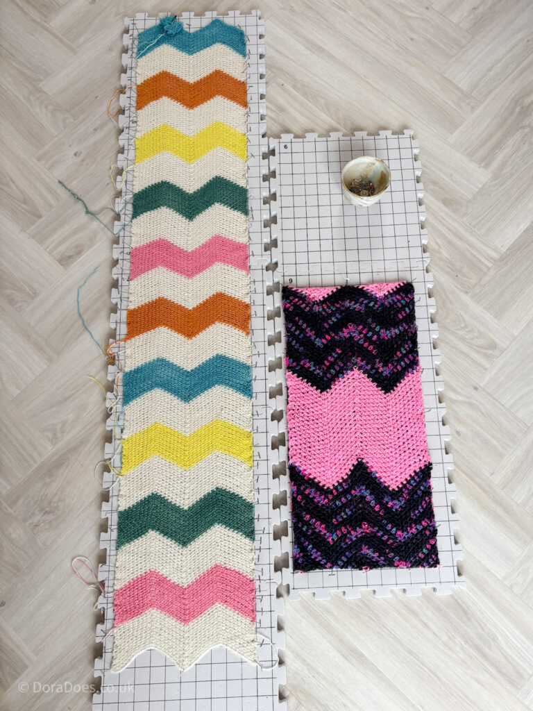 Two crochet scarves made up of coloured chevrons are pinned out to blocking boards.