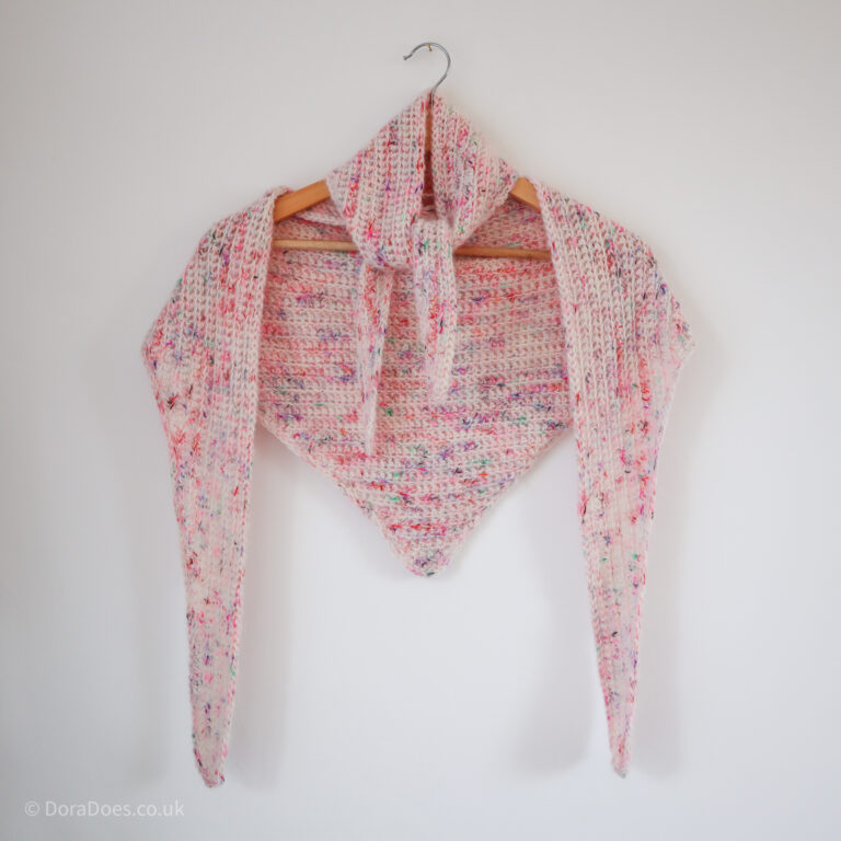 Two fluffy multicoloured mohair and wool crochet scarves are draped around a hanger.