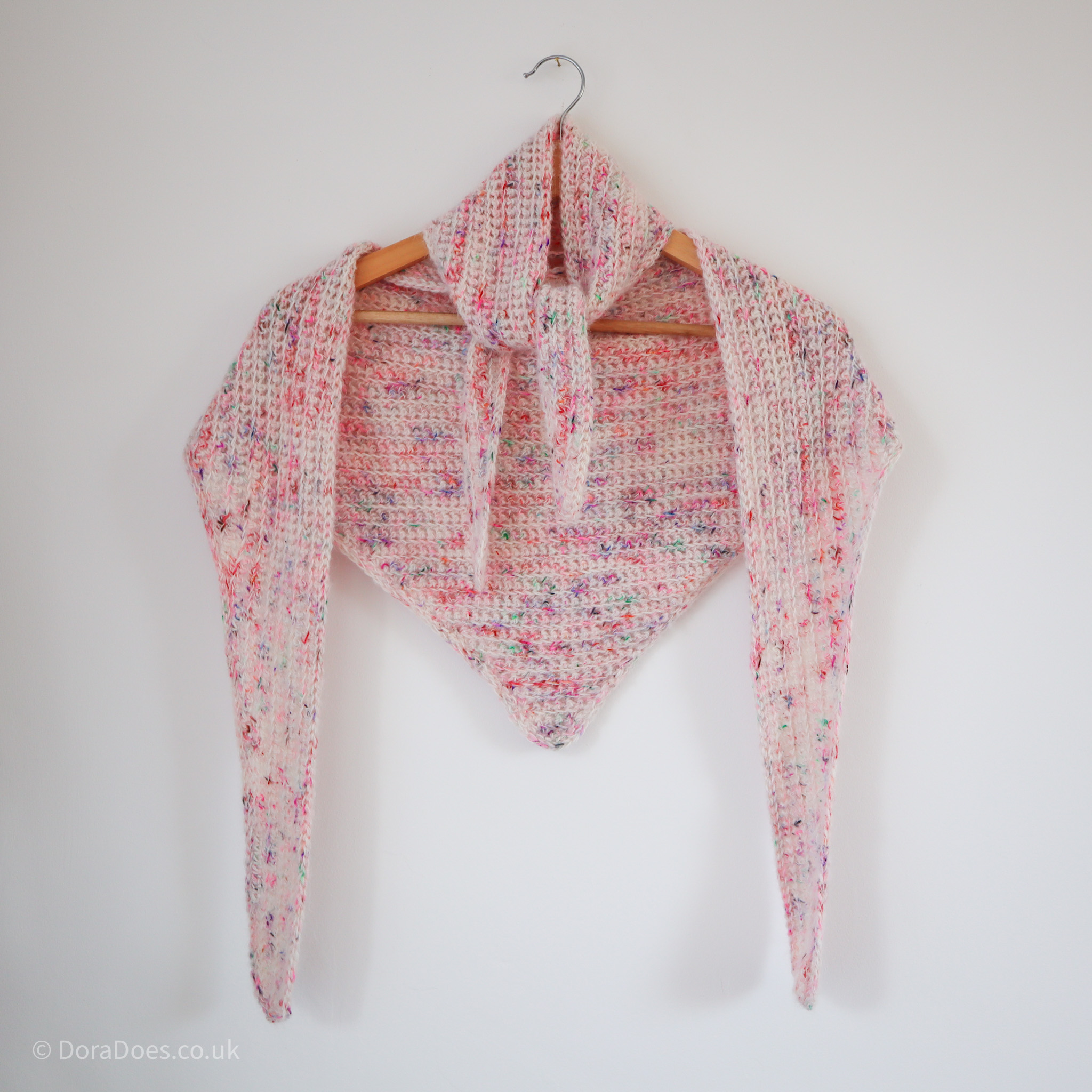 Two fluffy multicoloured mohair and wool crochet scarves are draped around a hanger.