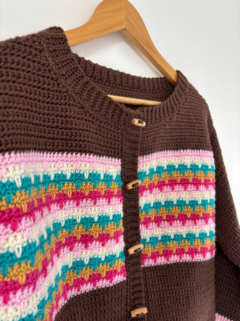 A close up view of the neckline, button band ad interlocking stripe pattern on the ‘lark cardgian’ crochet pattern.
