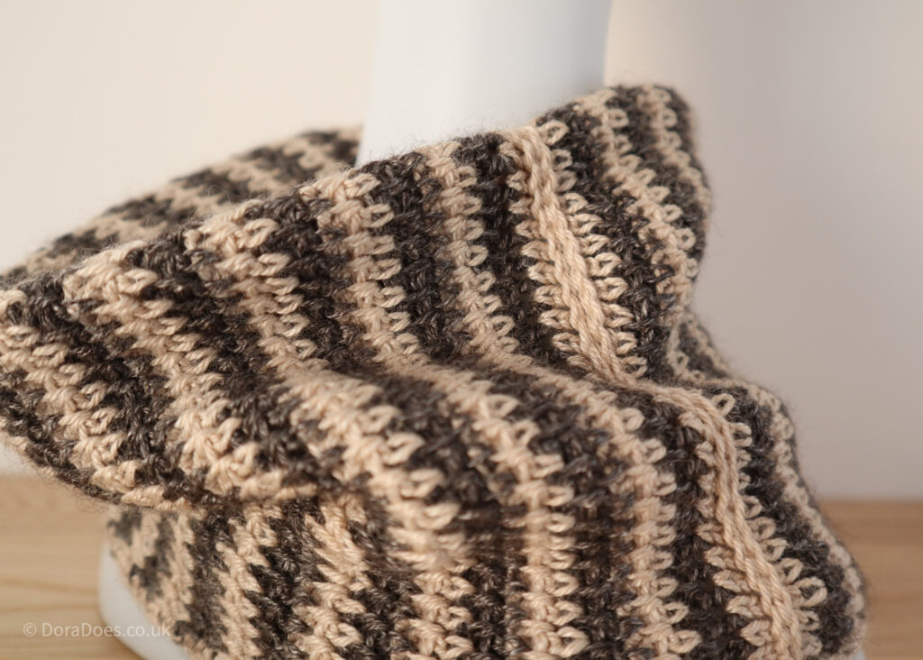 A close up of the ‘between the thorns’ crochet cowl on a mannequin with the crochet stitches showing the detail of the join.