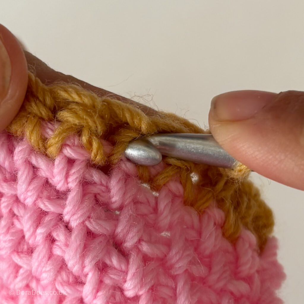 A close up showing where to insert your crochet hook when working between the posts of single crochets.